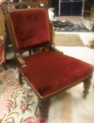 A Victorian ladies salon chair with red upohlstery raised on ringed and turned legs to brass caps