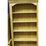 A modern pine six shelf open bookcase together with two further modern pine bookcases