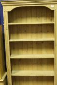 A modern pine six shelf open bookcase together with two further modern pine bookcases