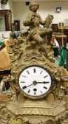 A French mantle clock with a gilt brass body featuring artist to the top,