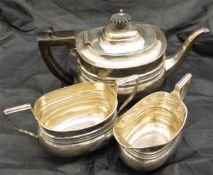 A silver teapot, cream jug and sugar bowl with ribbed decoration (by Holland, Aldwinckle & Slater,