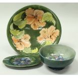 A William Moorcroft bowl decorated with pink flowers on a green ground,