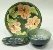 A William Moorcroft bowl decorated with pink flowers on a green ground,