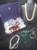 A box of assorted costume jewellery to include various brooches, necklaces, bangles, earrings,