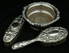 A pair of Alpacca embossed dressing table brushes and a plated wine coaster