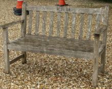 A teak garden bench, the slatted back carved "K.R.