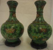 A pair of Chinese cloisonné vases decorated with flowers on a green ground stamped "China" to base