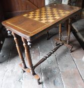 A mahogany and satinwood inlaid games table with twin end pillar supports united by a turned