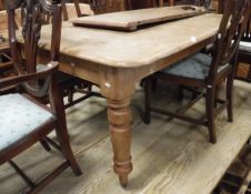 A Victorian pine extending dining table raised upon four turned supports to brown china castors