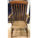 An elm seated slat back carver chair on turned supports, bears makers stamp "E.S.