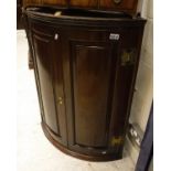 A circa 1800 oak hanging corner cupboard with two fielded panel doors enclosing three shelves