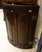 A circa 1800 oak hanging corner cupboard with two fielded panel doors enclosing three shelves