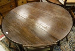 A 19th Century mahogany oval drop-leaf dining table on turned tapering legs to pad feet