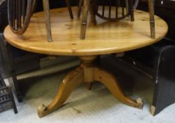 A modern pine circular kitchen table on tripod base,