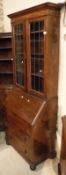 A 20th Century oak bureau bookcase with leaded glazed doors enclosing shelves with a fall above