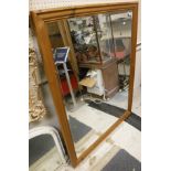 A large rectangular bevelled mirror in pine frame