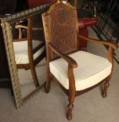 A caned back chair and a rectangular wall mirror