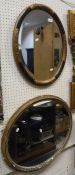 An oval bevelled mirror with blue painted and gilt floral decorated frame,