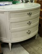 A white painted bow fronted three drawer commode in the French taste