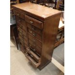 An oak eighteen drawer filing cabinet on a plinth base