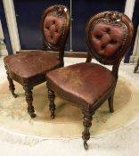 A set of six Victorian dining chairs with heavy carved backs and leather backs and seats above