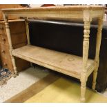 A pine two tier hall table on turned supports to white china castors