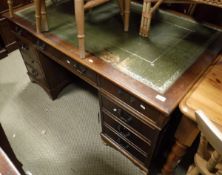 A mahogany pedestal desk with green leatherette inset top