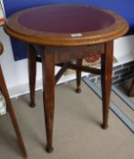 A pair of oak and red leather inset top circular tavern tables on turned supports