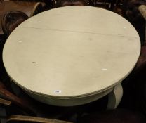 An Edwardian cream painted extending dining table of oval form