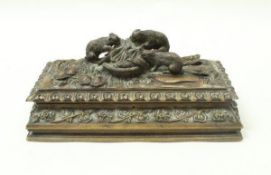 A carved black forest type music box in walnut, the lid with three carved rabbits feeding,