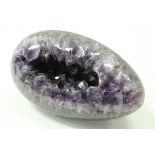 A Brazilian amethyst carved and polished geode in the form of an egg,