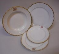 A Berlin KPM part dinner service, the centre white ground within a gilt decorated shaped border,