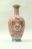 A Chinese famille rose vase with all over floral and foliate decoration and bats on a pink ground,