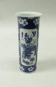 A Chinese blue and white cylinder vase with flared rim decorated with panels of household items on