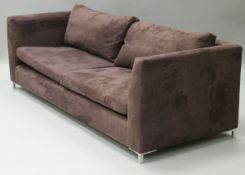 A pair of Alcantara fabric wine coloured three seat sofas on aluminium square supports,