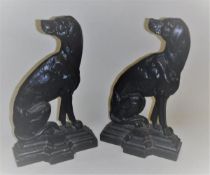 Two iron door stops cast as seated dogs looking backwards with Victorian diamond kite marks verso,