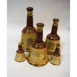 A collection of five pottery Bells Old Scotch Whisky bell-shaped bottles,