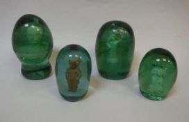 Four Victorian green glass dump paperweights with plaster inset figures, to include one of dog,