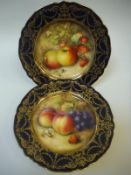 A pair of Royal Worcester cabinet plates, one centre field decorated with apples and strawberries,