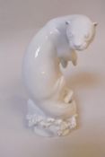 A Meissen Weiss model of an otter by M Esser, crouched upon a rocky base,