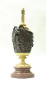 A bronze vase-shaped lamp base, the body with handles of goat mask form,