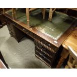A mahogany pedestal desk with green leatherette inset top