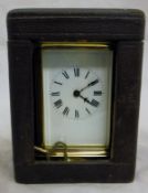 A brass carriage clock with Roman numerals to the enamel dial,