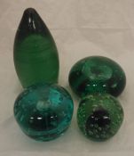 Three Victorian green glass dumps as doorstops and one as a paperweight with blue swirl and bubble