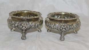 A matched pair of silver salt cellars with shell and C scroll applied decoration to the rim and