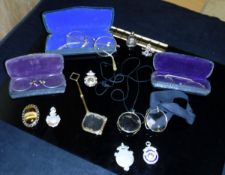 A box containing various vintage glasses, four silver and enamelled medallions,