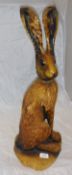 A carved treen figure of a hare sitting on its' haunches