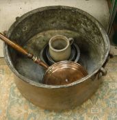 A large Middle Eastern waisted copper cauldron, a wooden handled copper warming pan,