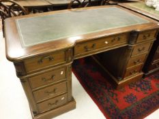 A modern mahogany double pedestal desk with tooled and gilded leather writing surface over a