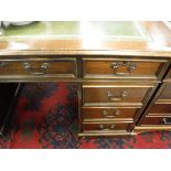 A modern mahogany double pedestal desk with tooled and guilded leather insert top over three